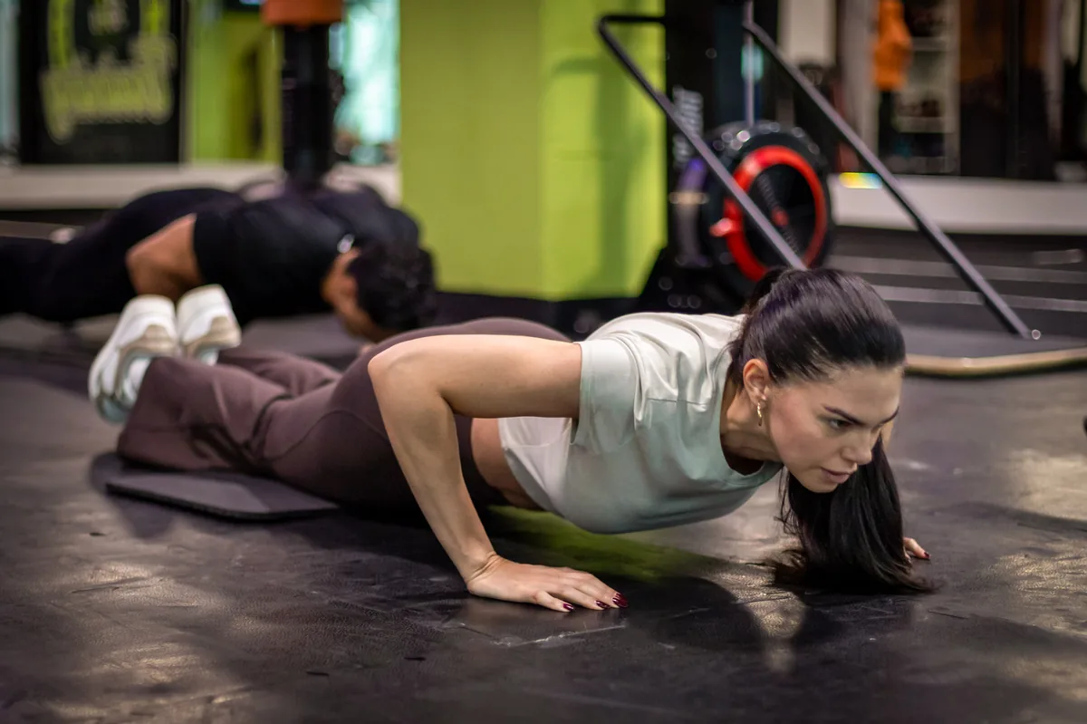Fase baja del burpee con push-up en el piso durante entrenamiento XT30.60